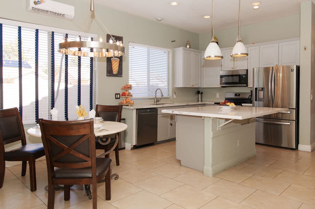 The kitchen and breakfast area, with a round table and chairs by the window and the kitchen island beyond.